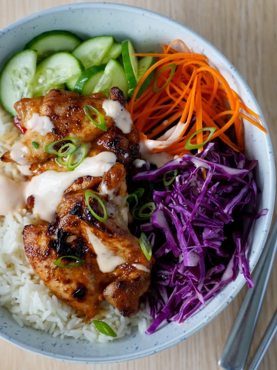 A bowl of Bang Bang Chicken with salads and steamed rice