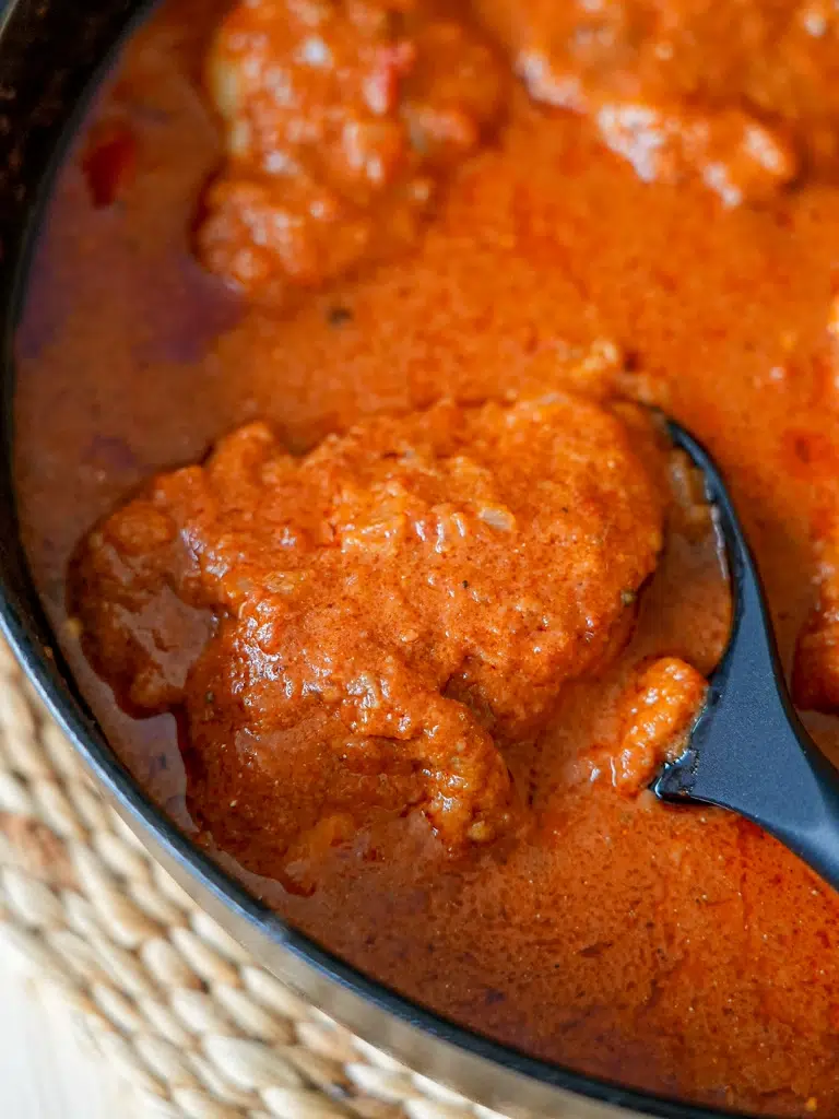 A pan of Chicken Paprikash featuring tender chicken pieces in a rich paprika sauce
