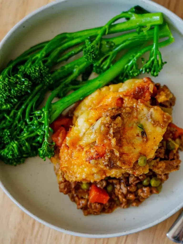 Shepherd's Pie served in a bowl with fresh greens on the side