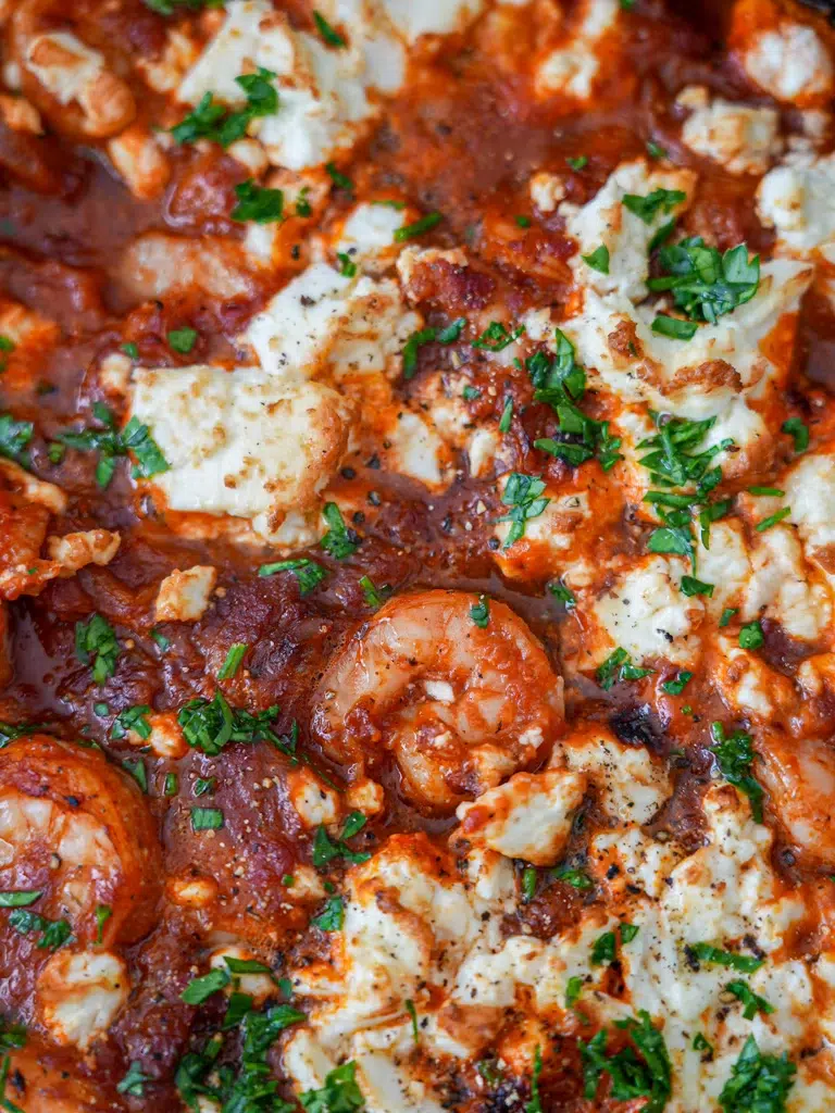Detailed view of Prawn (Shrimp) Saganaki with vibrant tomatoes, feta cheese, and parsley.
