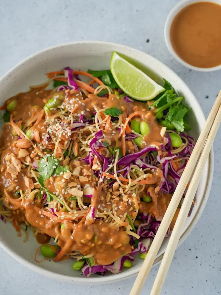 Cold Sesame Peanut Pasta Salad in a bowl and a pair of chopsticks on top.