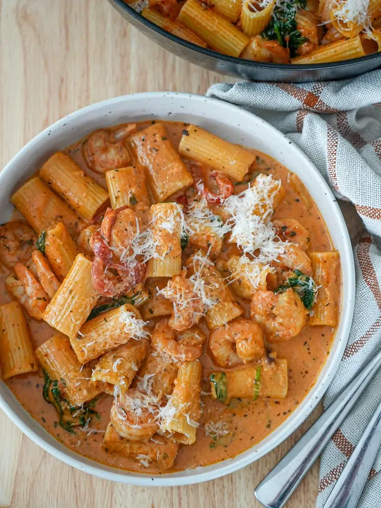 Overhead view of Creamy Cajun Prawn Pasta in a pan with a serving spoon.