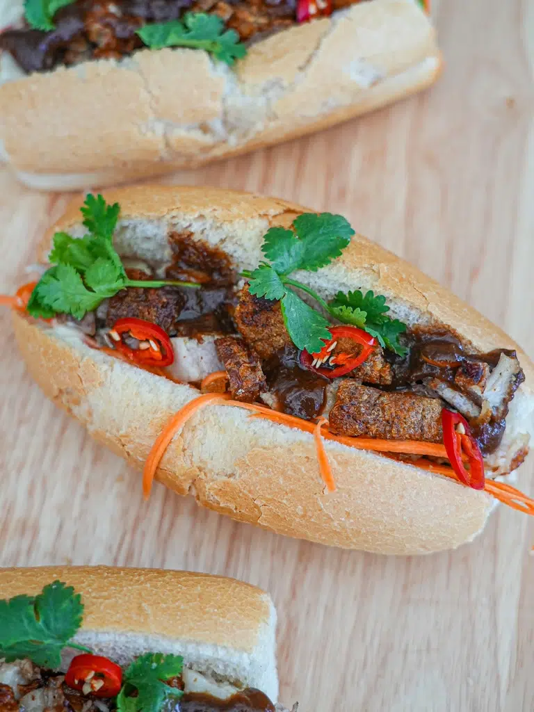 Freshly prepared Pork Belly Banh Mi topped with finely sliced red chili and cilantro leaves