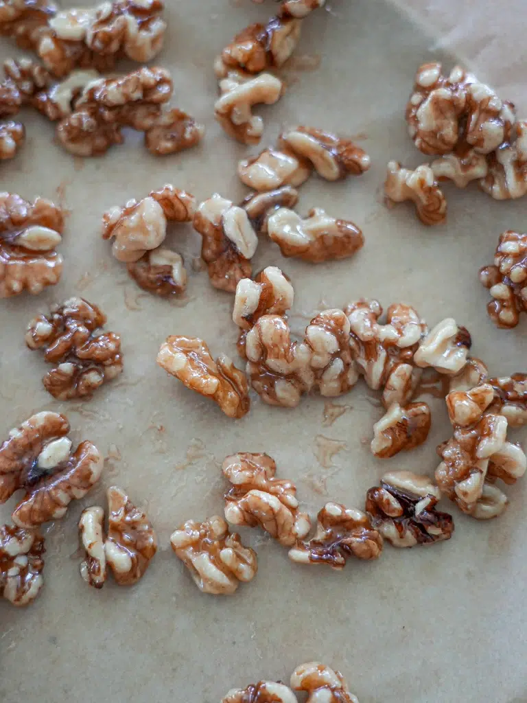 Candied walnuts arranged on a plate, glistening with a sweet coating.