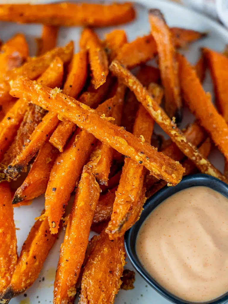 Close-up of crispy sweet potato fries with creamy gochujang mayonnaise.