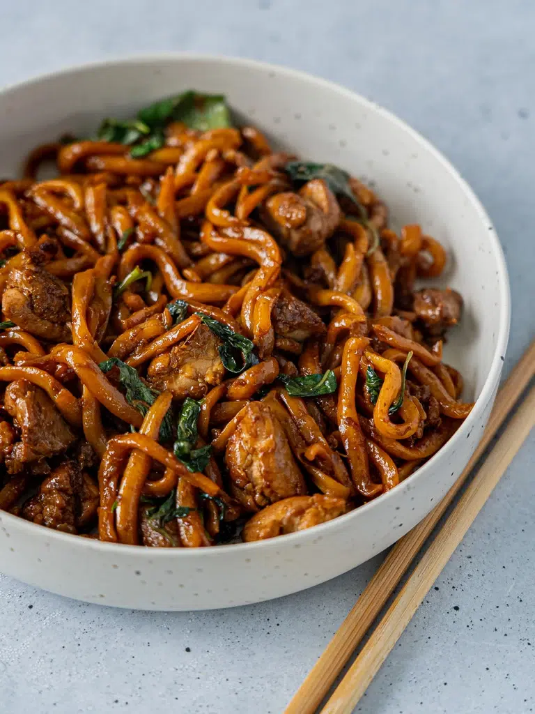 Close-up of a bowl of Three-Cup Chicken Noodles, featuring tender chicken, noodles, and a flavorful sauce.