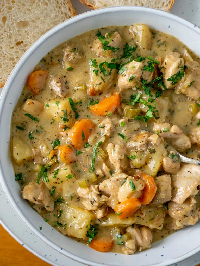 Overhead shot of hearty chicken stew in a bowl with a spoon