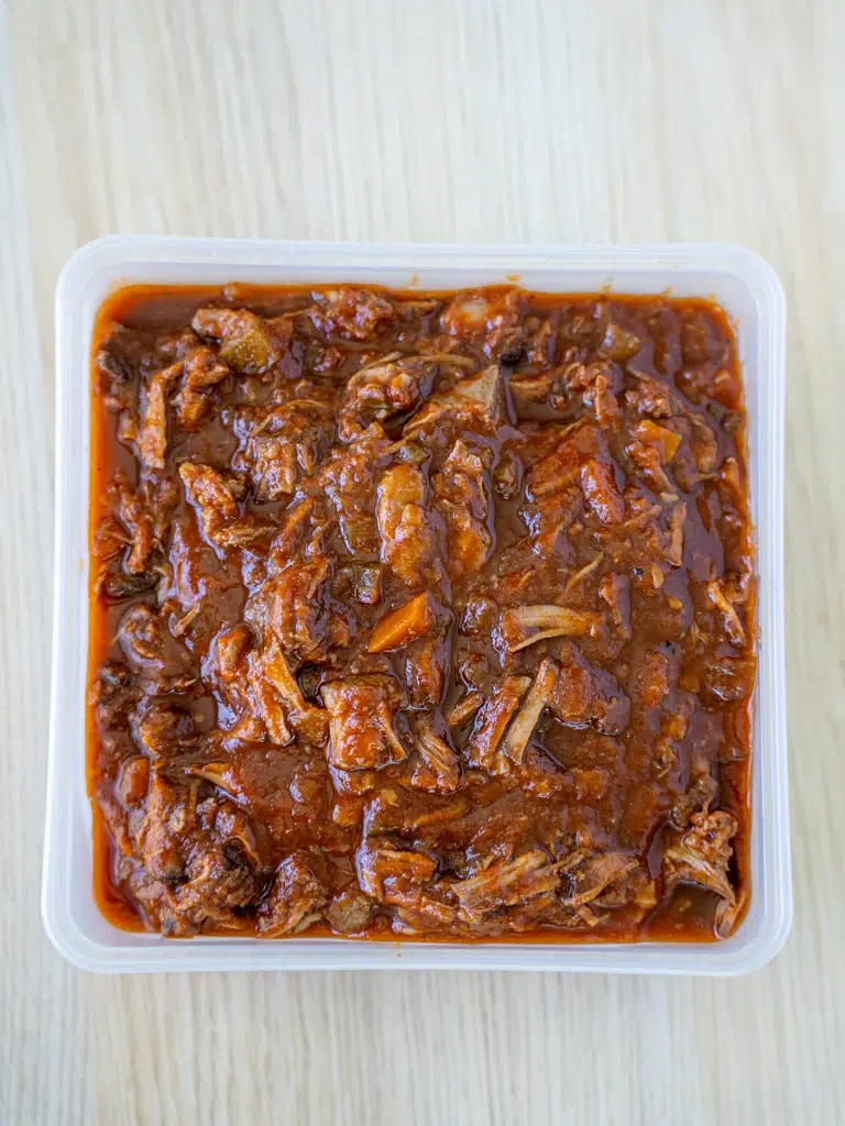 Flavorful beef ragu in a container, perfect for meal prep.