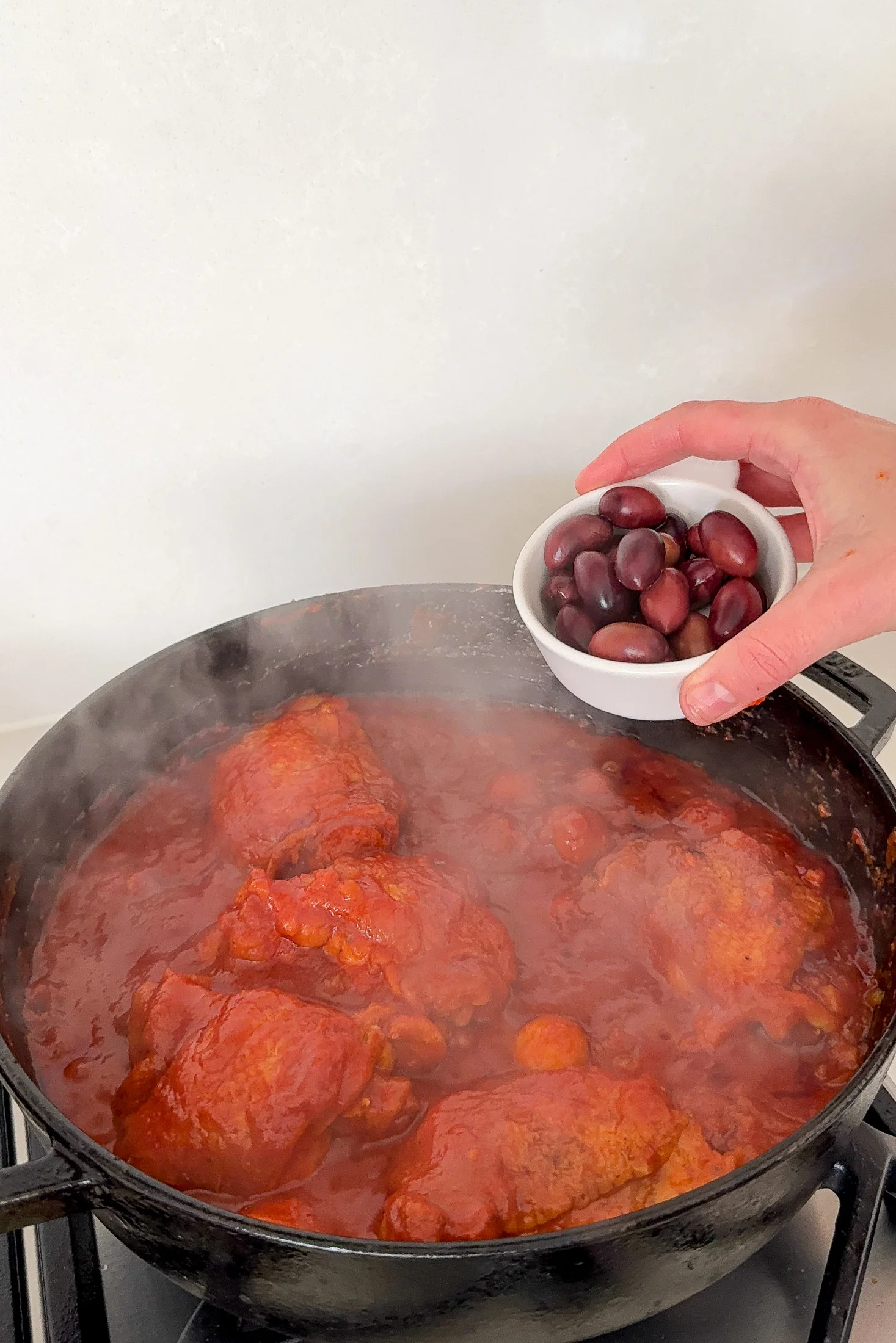Kalamata olives and capers scattered over chicken cacciatore