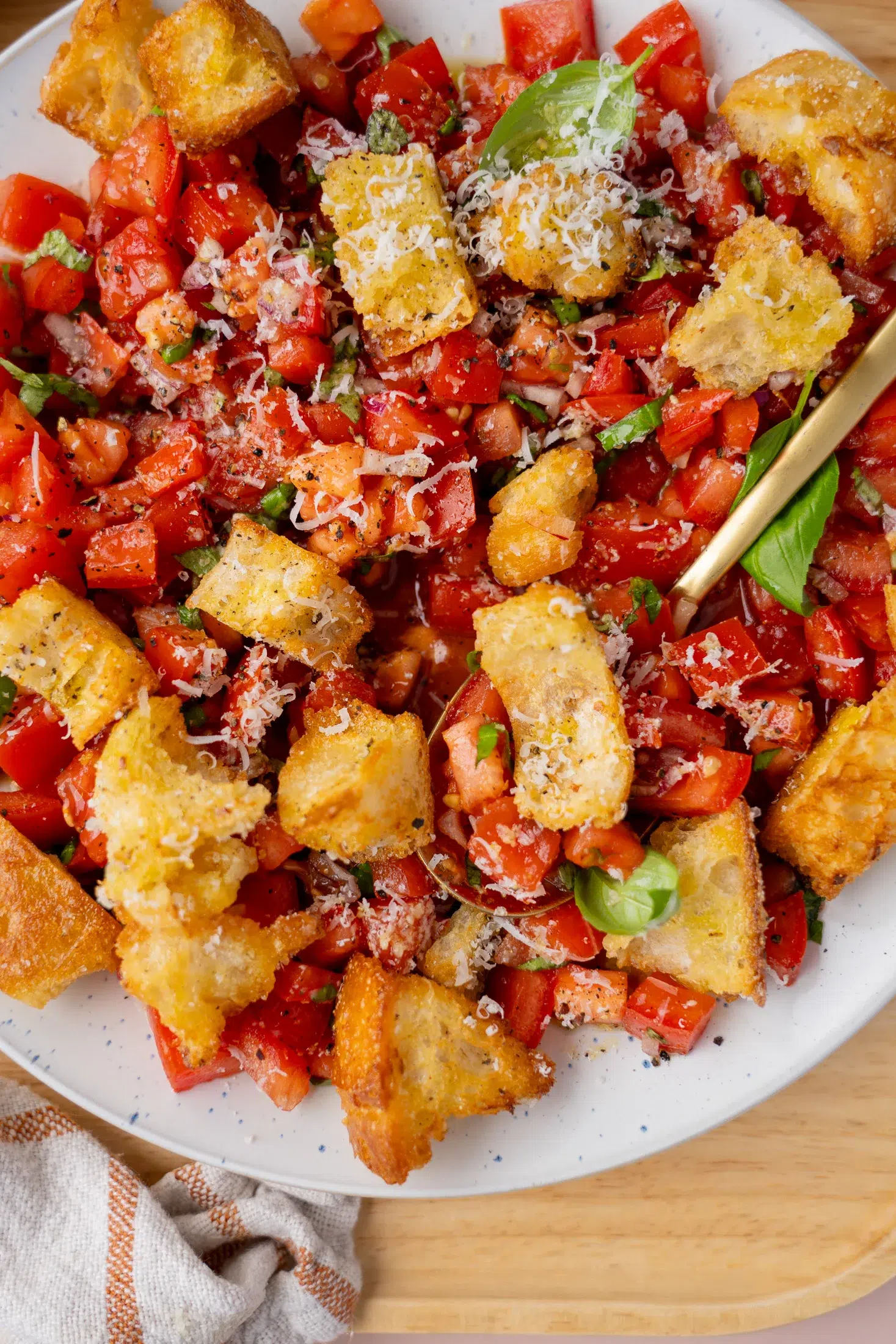 Bruschetta salad with crispy garlic parmesan croutons served with a spoon