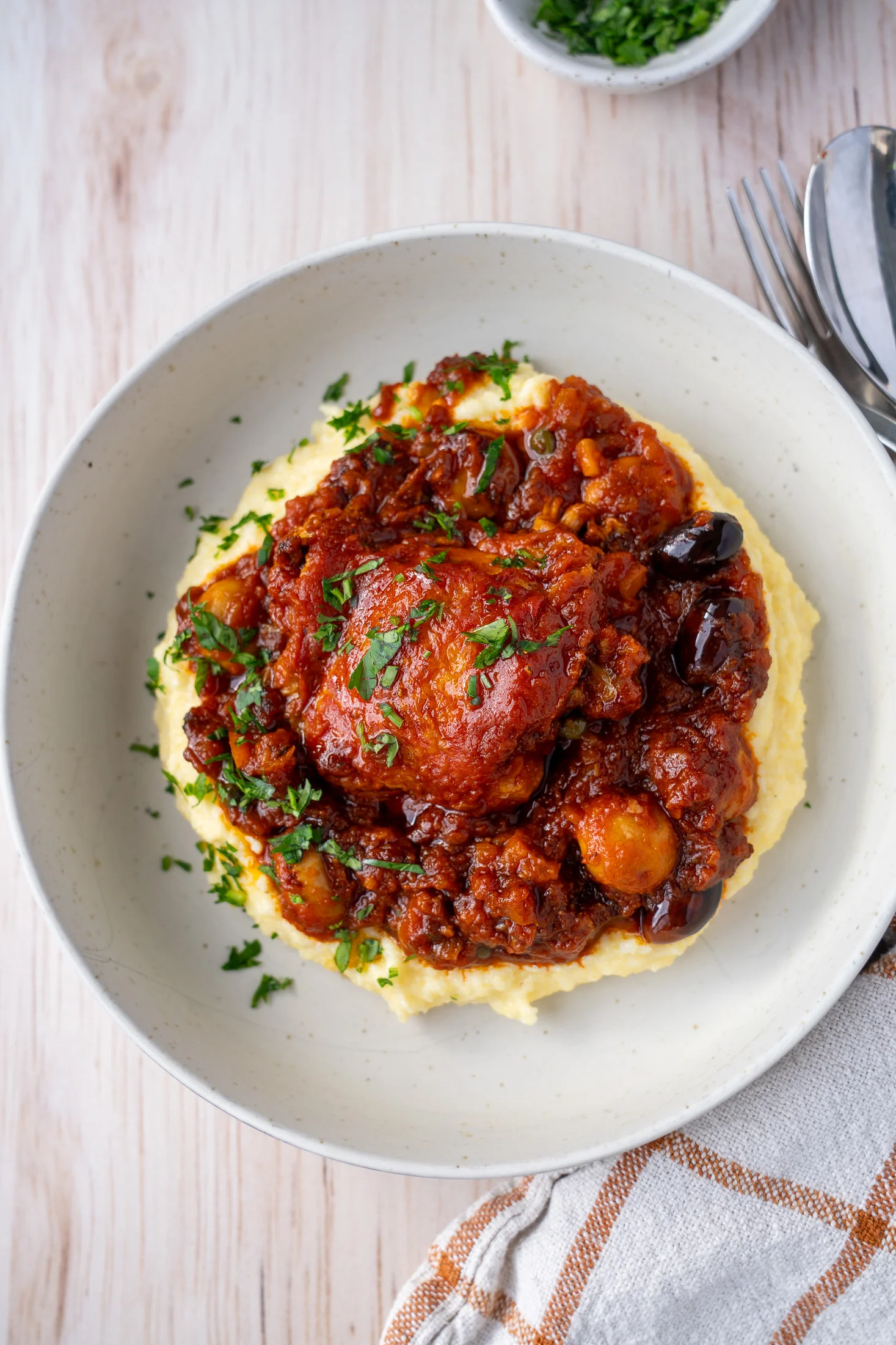 Chicken cacciatore and polenta garnished with fresh parsley