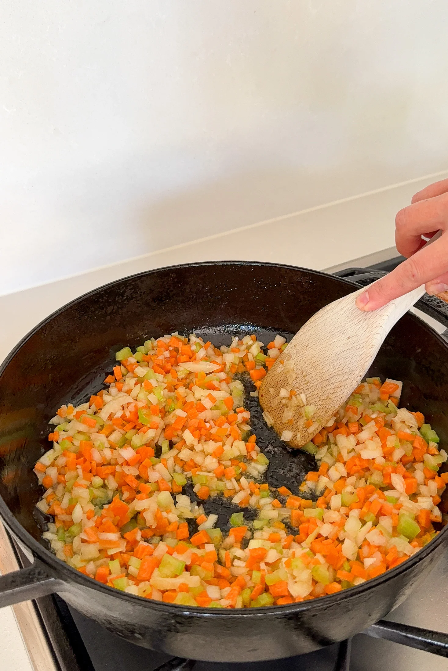 Softened soffritto vegetables beginning to melt into the pan