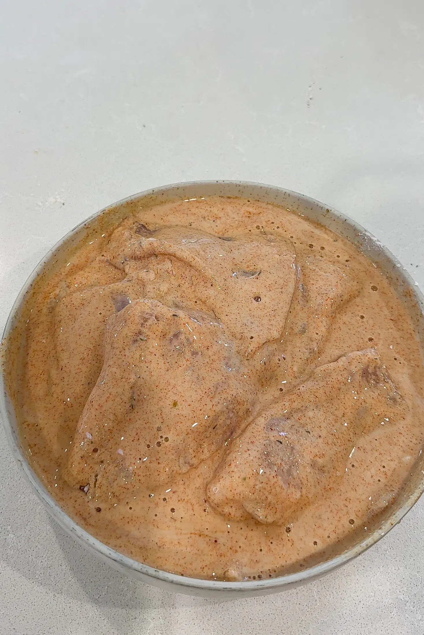 Chicken pieces soaking in seasoned buttermilk marinade