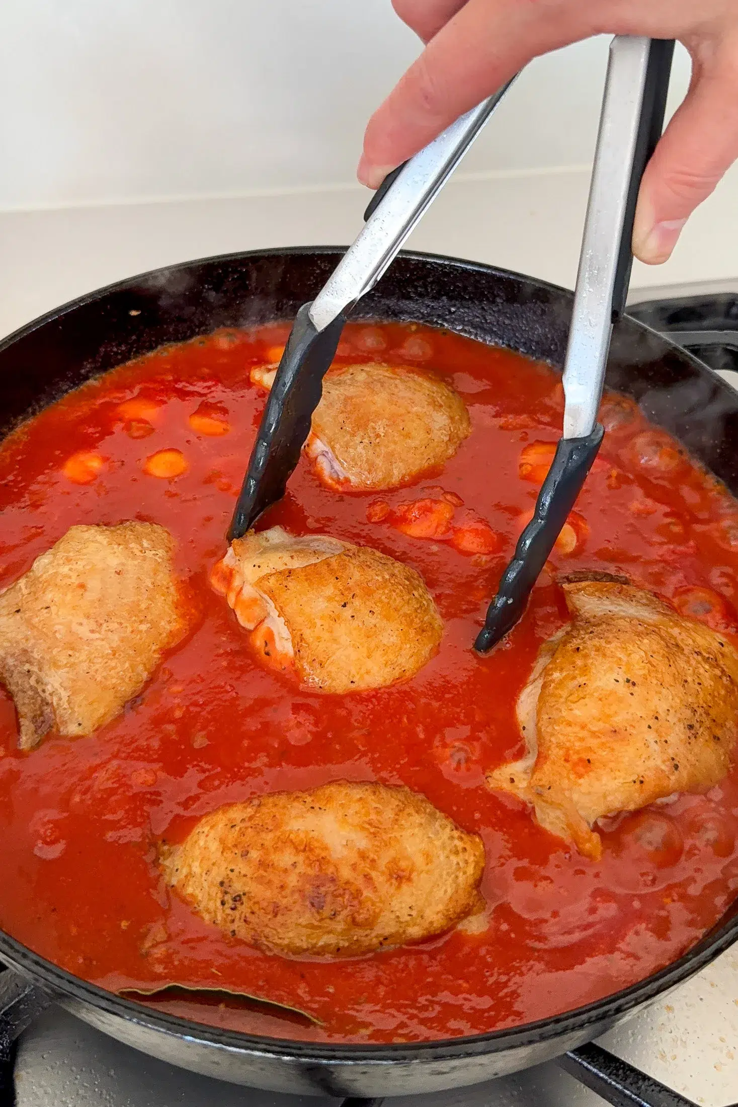 Browned chicken thighs nestled into rich tomato sauce
