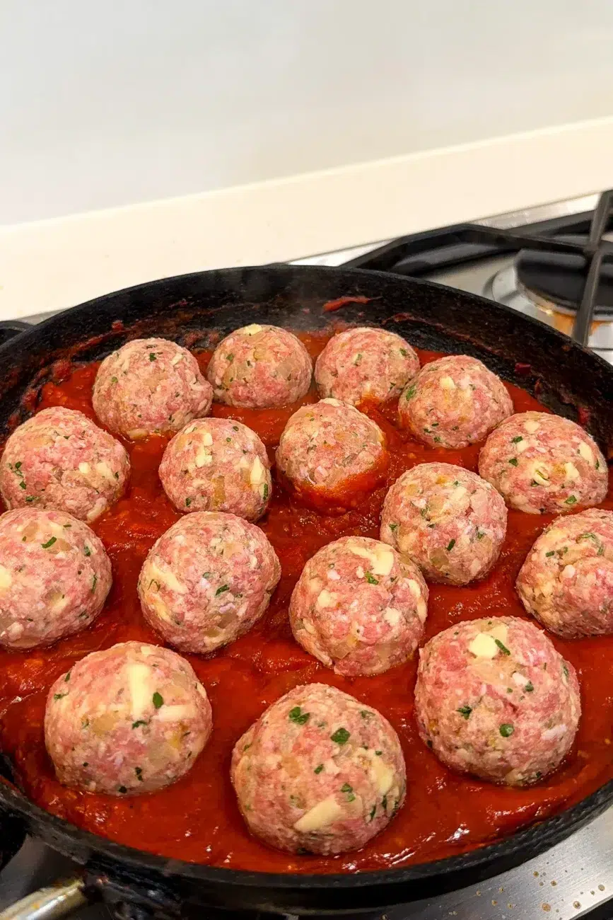 Meatballs rolled and added to the tomato sauce