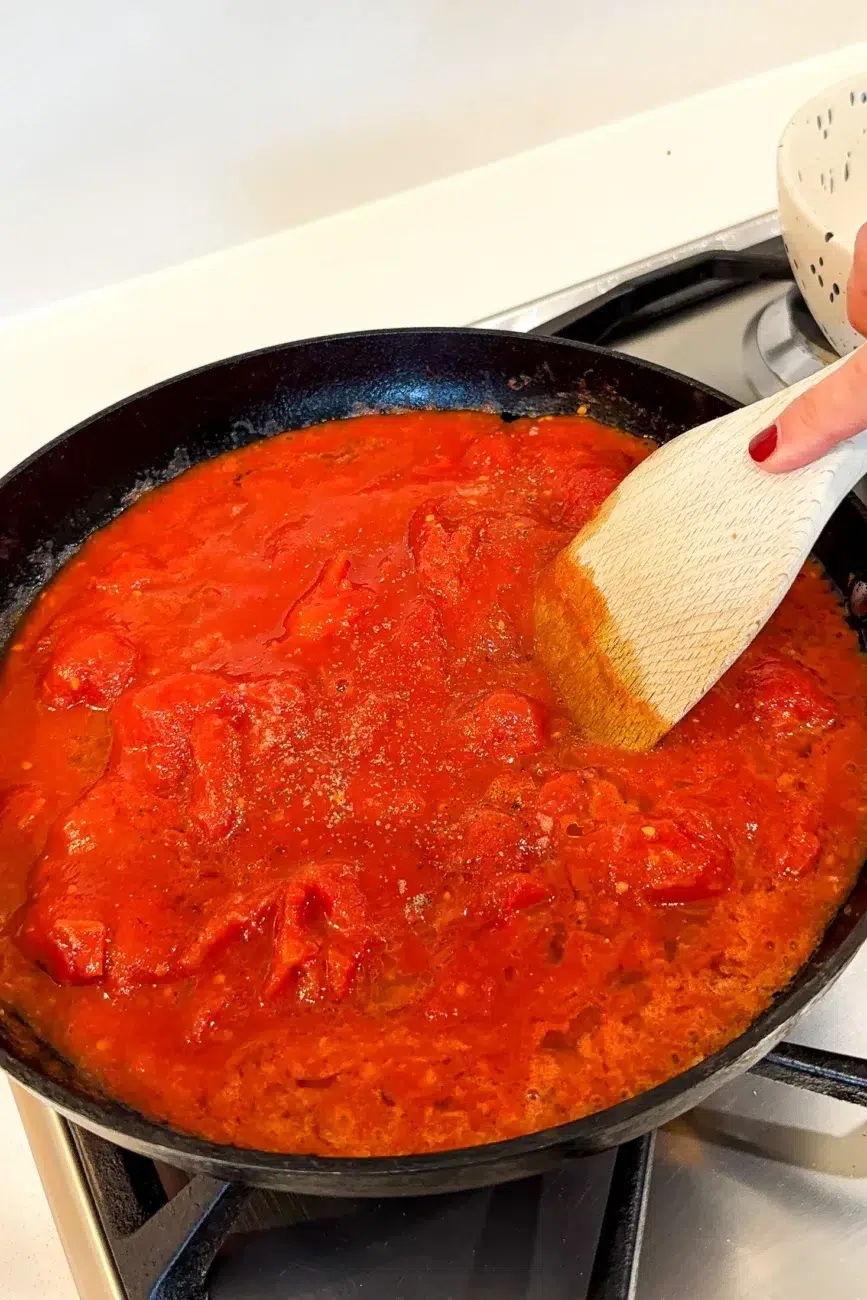 Tomatoes added to the pan and gently crushed